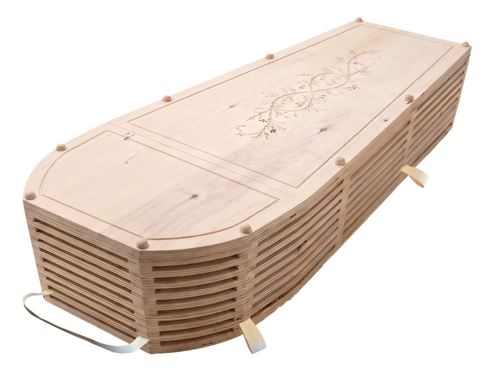 The Cypress green burial casket, a light natural wood casket with slatted sides and a carved botanical motif on the lid